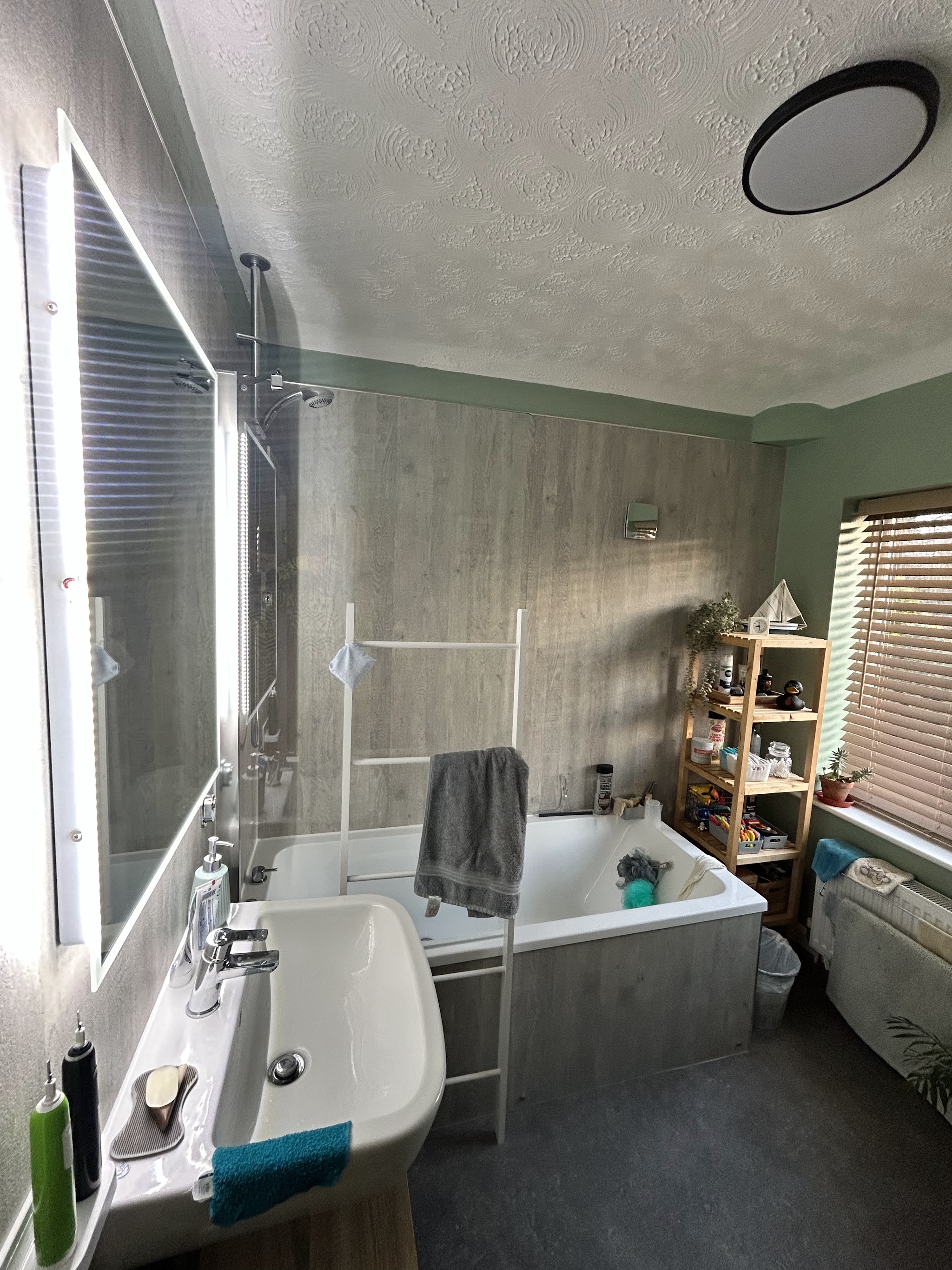 Bathroom with wood-effect wall panelling, a bath and a large basin