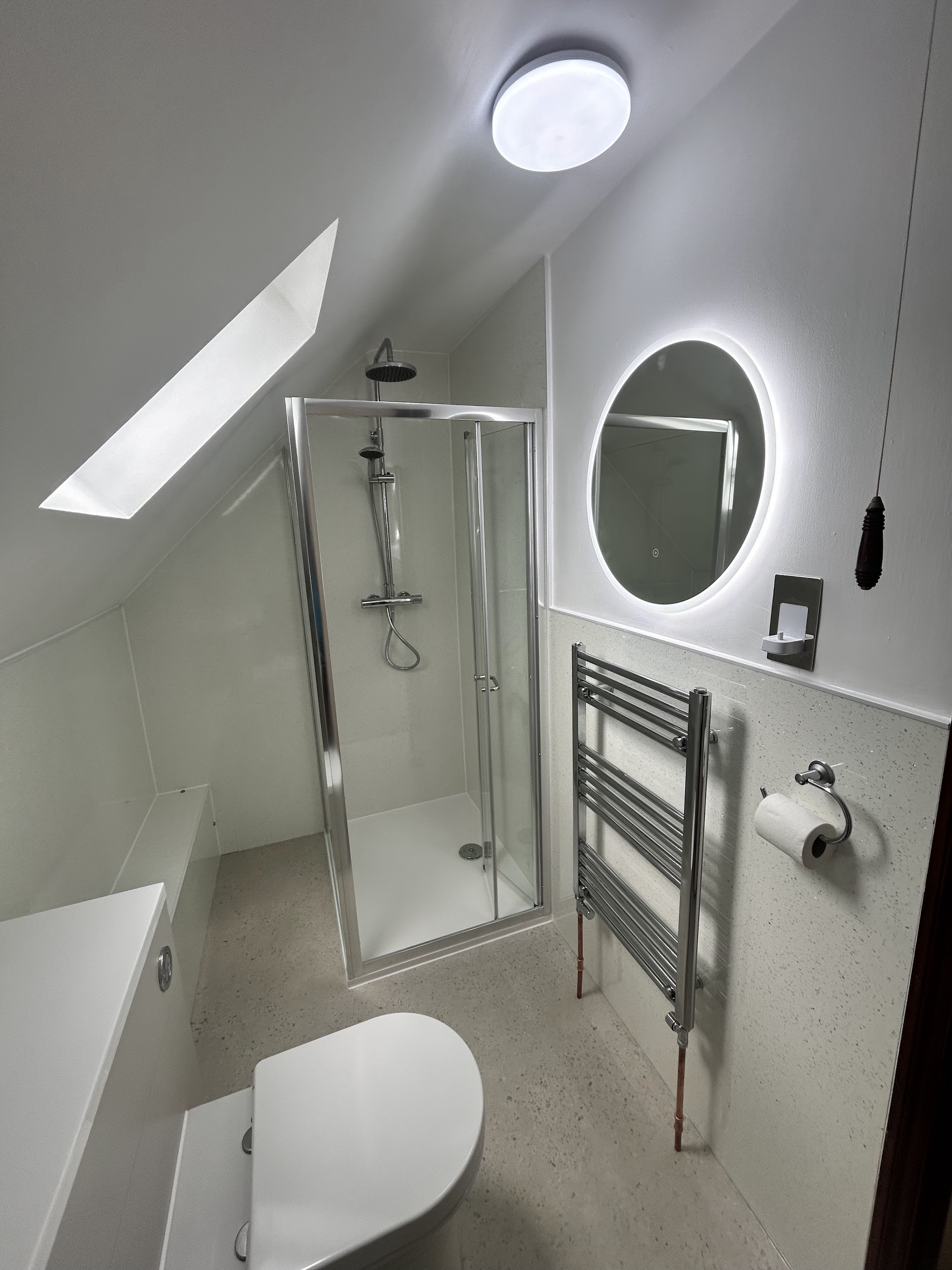 Loft shower room with a skylight, LED mirror and chrome towel rail